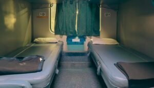 Two beds made up inside a sleeper train cabin